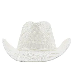 Detail view of a white hand-woven straw cowboy hat with intricate crochet hollow patterns