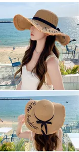 Close-up of 'Hello Sunshine' embroidery on a wide-brimmed straw beach hat