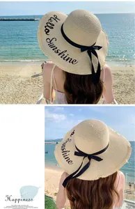 Stylish woman wearing straw sun hat with 'Hello Sunshine' embroidery on a sunny beach resort
