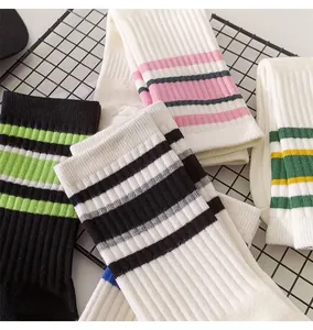 Close-up of various colorful striped crew socks for women on a black grid rack.