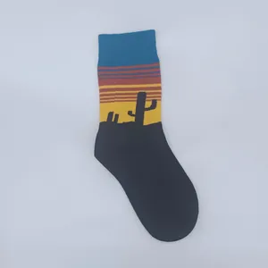 Detailed view of knitted crew sock featuring a colorful desert sunset and cactus motif.