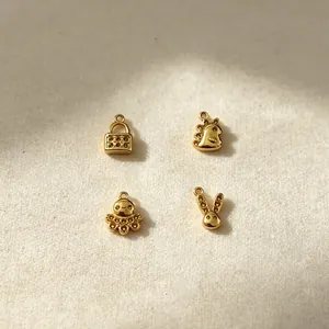 Detailansicht vergoldeter Edelstahl-Anhänger mit Oktopus, Hasen, Dino und Schlossmotiven