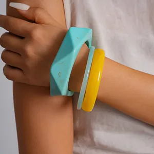 Detail van een retro hars armbandset met geometrische vormen en marmeren texturen