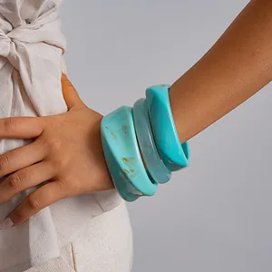 Gedetailleerd overzicht van drie grove turquoise gemarmerde hars armbanden om pols