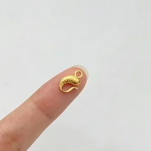 Nahaufnahme eines goldenen Koi-S-Haken-Schmuckverschlusses auf einem Finger zur Skalierung.