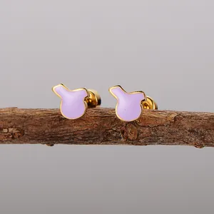 Κοντινό πλάνο με μωβ σκουλαρίκια από σμάλτο σε ένα φυσικό ξύλινο κλαδί για διακόσμηση