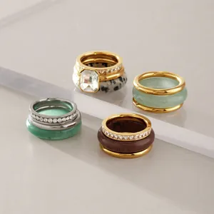Close-up of stackable rings featuring natural stone and gold-plated stainless steel.