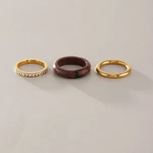 Detail of natural stone and stainless steel ring set with gold finish and zircons.