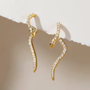 Detailed shot of gold-plated snake earrings with sparkling rhinestone embellishments