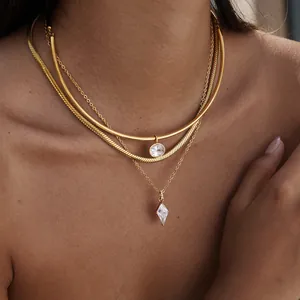 Gros plan détaillé d'un collier doré multicouche avec des pendentifs en cristal sur peau