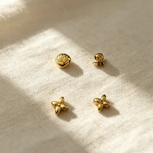 Close-up of golden stainless steel beads in shell, octopus, and clover shapes