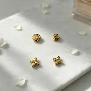 Close-up of gold stainless steel beads featuring shell, octopus and four-leaf flower shapes