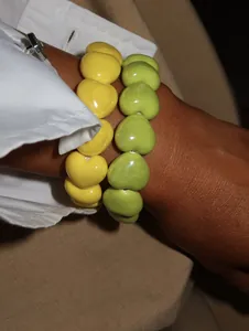 Detailed view of glossy yellow and green heart-shaped beaded elastic bracelets