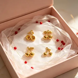 Detailansicht von vier goldenen Edelstahl-Kirschanhängern in einer rosa Geschenkbox