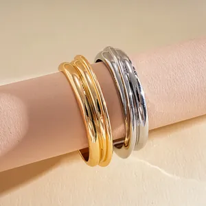 Close-up of minimalist gold and silver metallic textured geometric open cuff bangles