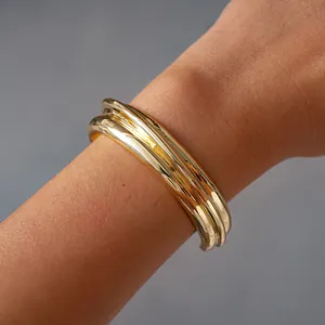 Detailed view of a stylish gold-colored geometric open bangle with a smooth metallic texture