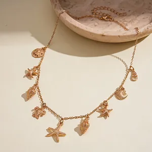Dettaglio della collana dorata a tema marino con ciondoli a forma di stella e conchiglia