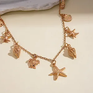 Primo piano di una collana in metallo dorato con ciondoli marini come stelle marine.