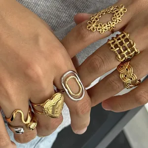 Close-up detail of stylish stainless steel rings with hollow heart and floral patterns.