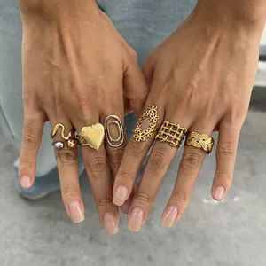 Detailed view of various 18k gold plated stainless steel rings styled on model's fingers
