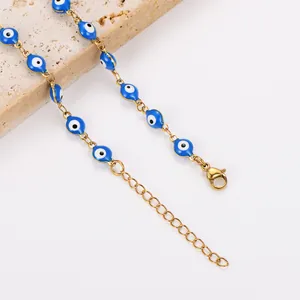 Détail d'une chaîne de cheville bohème en acier avec des charms œil bleu émaillés