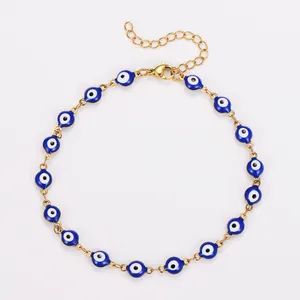 Vue détaillée d'un bracelet de cheville en acier doré avec des perles œil grec bleu.