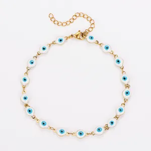 Bracelet de cheville doré en acier avec des breloques œil bleu en émail en détail.