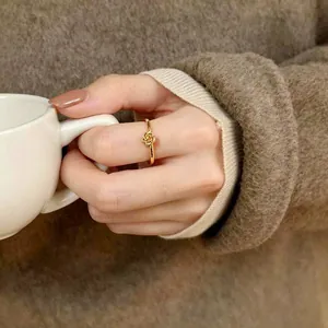 Detailansicht eines eleganten 18K vergoldeten Rosenblütenrings, der am Finger getragen wird