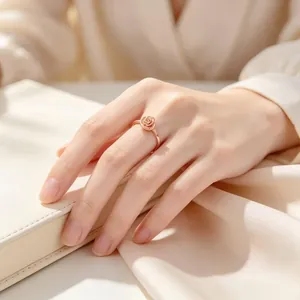 Detailaufnahme eines eleganten, 18 Karat vergoldeten Rosenrings aus Titanstahl an der Hand.