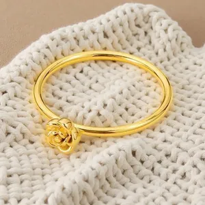 Detailaufnahme eines eleganten, 18 Karat vergoldeten Rosenrings auf Strickstoff