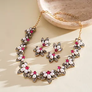Detailansicht der Vintage-Blumenkette und Ohrringe mit Perlen und roten Steinen.