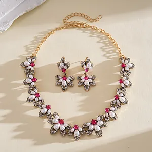Elegantes Blumenschmuck-Set mit rosa Strasssteinen und Perlen im Detail.
