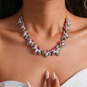 Detailaufnahme einer Vintage-Halskette mit weißen Perlen und rosa Strasssteinen.