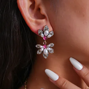 Detailaufnahme von Vintage-Ohrringen im Palaststil mit rosa Kristallen und Perlen.