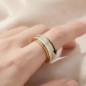 Vue détaillée d'une bague rotative dorée avec un sertissage complet de zircons.