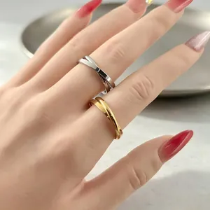 Close-up view of minimalist interlaced double-loop stainless steel rings on a hand