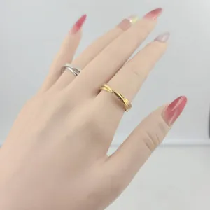 Close-up of interlocking stainless steel double ring in gold and silver finish on hand