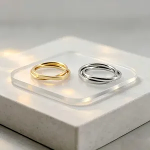 Close-up of gold and silver interlocking stainless steel rings on a minimalist display.