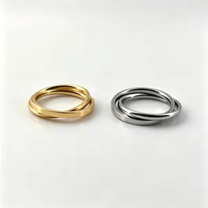 Detailed close-up showing interlocking stainless steel bands in polished gold and silver.