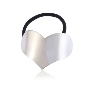 Close-up of a silver brushed metal heart-shaped hair tie with black elastic band.