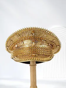 Detailed view of a gold captain hat with glittering sequins and punk metal spikes