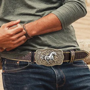Dettaglio cintura cowboy con fibbia a cavallo d'argento e borchie metalliche