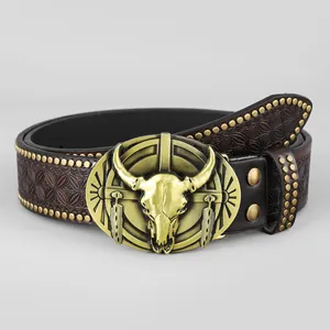 Dettaglio di una cintura in pelle stile cowboy con fibbia teschio di toro e borchie