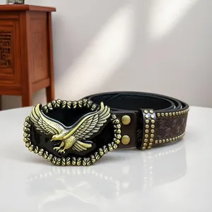Dettaglio di una cintura in pelle cowboy western punk con fibbia ad aquila e borchie