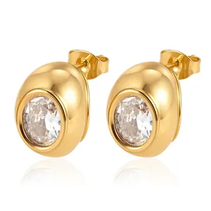 Détail macro de boucles d'oreilles géométriques en acier doré 18K avec zircons clairs