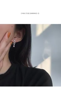 Gros plan d'une boucle d'oreille clou en argent style lave sur l'oreille d'un modèle