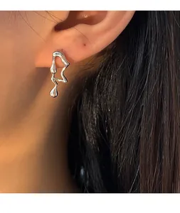 Gros plan d'une boucle d'oreille en argent style lave avec texture fondue irrégulière