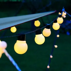 Close-up of glowing warm white G50 globe string lights for outdoor camping tent decoration