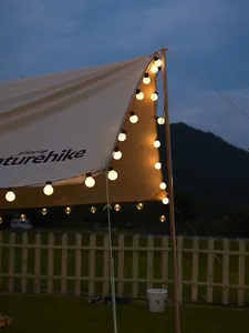 Warm white G50 LED globe string lights decorating an outdoor camping canopy at dusk