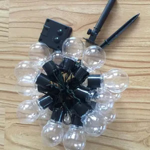 Close-up of G50 LED globe string lights with solar panel and ground stakes for camping.
